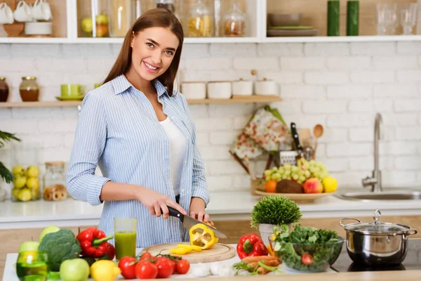 Matlagning grönsakssallad. Lycklig kvinna skär peppar — Stockfoto