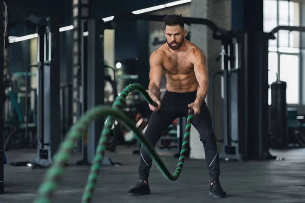 Homem de fitness trabalhando com cordas de batalha no ginásio — Fotografia de Stock