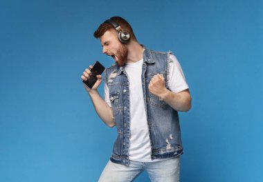 Genç duygusal milenyum adamı en sevdiği şarkıyı akıllı telefondan söylüyor.