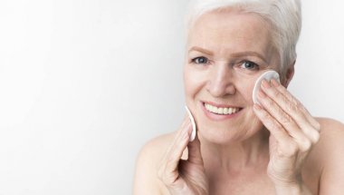 Micellar su ile pamuk ped kullanarak Lovely olgun kadın