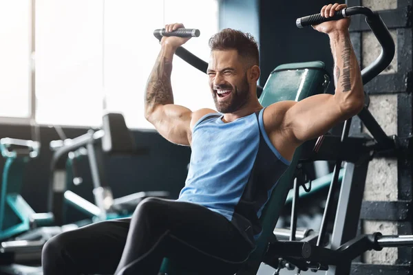 Bello uomo muscoloso che lavora duro in palestra — Foto Stock