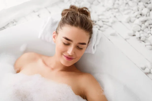 Mulher relaxante em Bathtube com espuma de sabão — Fotografia de Stock