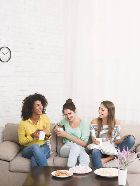 Три соседки по комнате с кофейными чашками проводят время вместе
