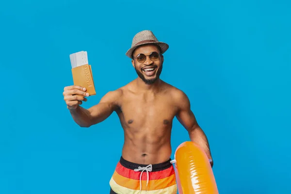 Vrolijke zwarte kerel in de zomer slijtage paspoort met kaartjes — Stockfoto