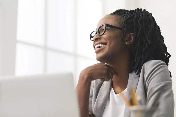 Sorrindo Afro mulher de negócios sentada no local de trabalho — Fotografia de Stock