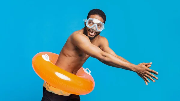 Tüplü maskeli siyah adam ve mavi üzerinde şişme halka dalış — Stok fotoğraf