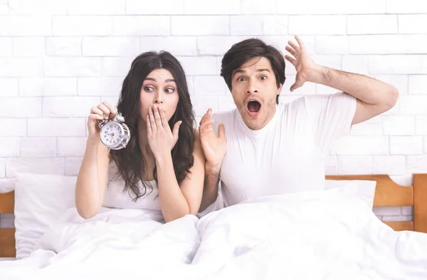 Mylić kilka nieodebranych dzwonienie budzik w łóżku — Zdjęcie stockowe