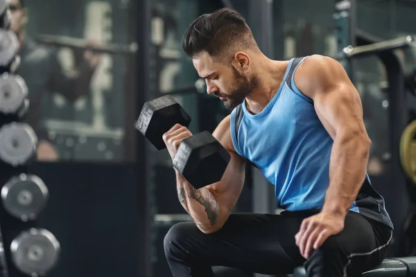 Testépítő pumpáló ő bicepsz a súlyzó az edzőteremben — Stock Fotó