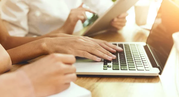 Female hands typing on laptop, close up