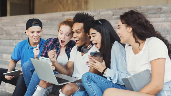 Känslomässiga tonårs studenter ser upphetsad i laptop — Stockfoto