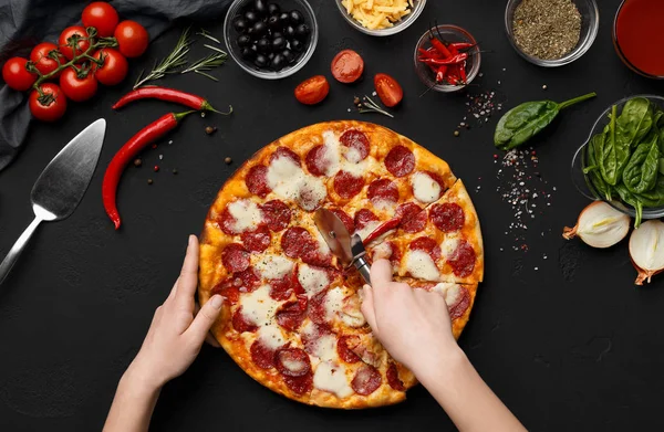 Koch schneidet heiße Pizza in Scheiben, Draufsicht — Stockfoto