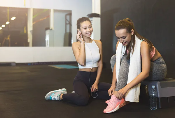 Przygotowanie do treningu. Kobiety sportowcy sznurowanie buty i rozmowa — Zdjęcie stockowe