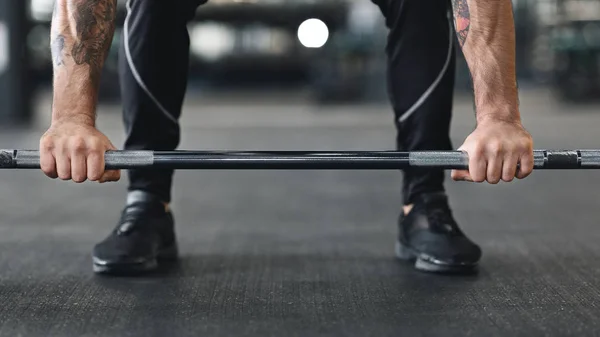 Barbell en el suelo y las manos del hombre en él — Foto de Stock