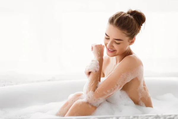 Jovem mulher desfrutando de banho de bolha e relaxante — Fotografia de Stock