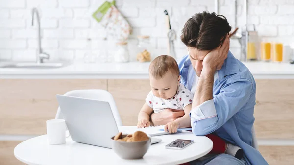 Millennial man tired of working and taking care of baby — Stock Photo, Image