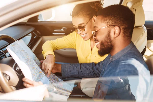 Concepto de viaje. Afro pareja usando mapa en coche —  Fotos de Stock