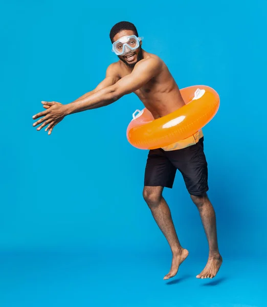 Fröhlicher schwarzer Mann ohne Hemd mit Schwimmbrille und aufblasbarem Ring — Stockfoto