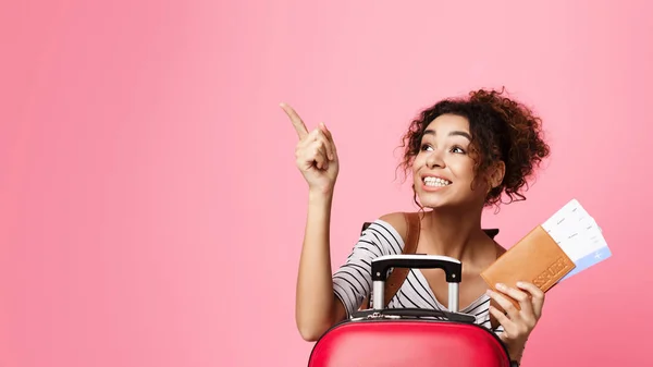 Felice ragazza che indica dito lontano, sfondo rosa — Foto Stock