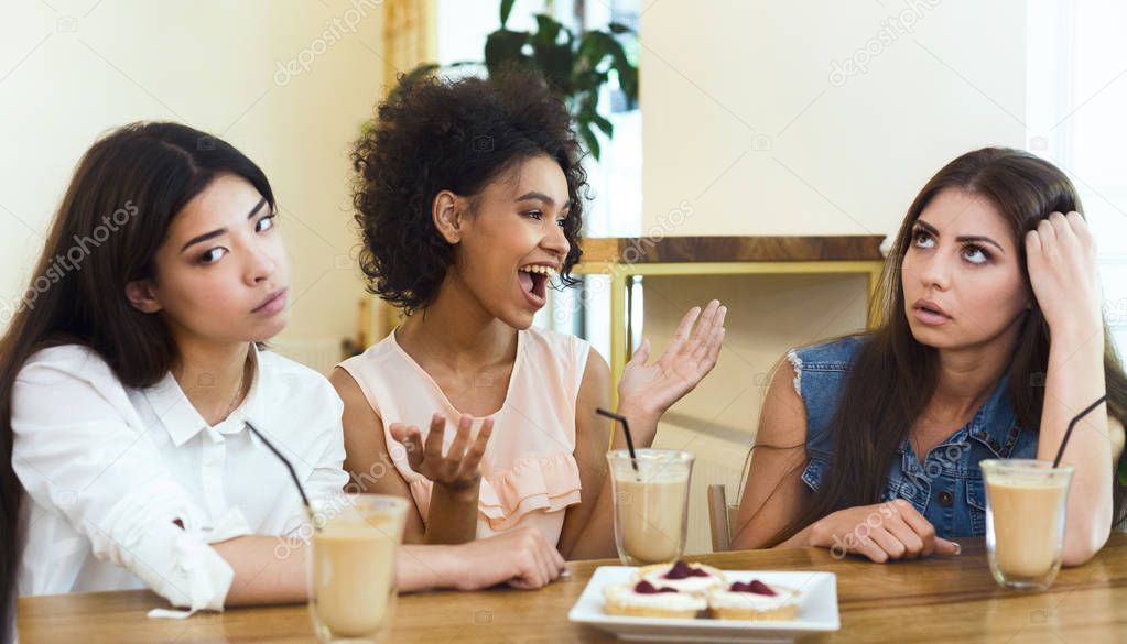 Annoying talkative friend sitting in cafe with girls