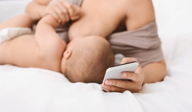 Bebek emzirme sırasında akıllı telefon kullanan bin yıllık anne