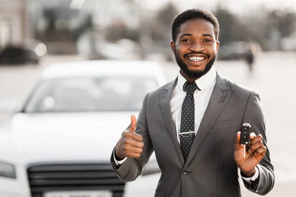 Щасливий покупець тримає ключі біля нового автомобіля — стокове фото