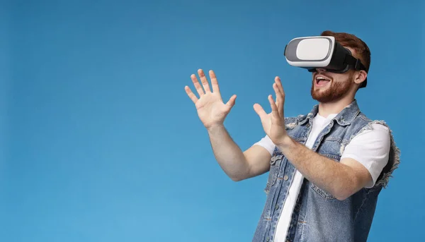 Happy young male touching invisible subject in vr glasses — Stock Photo, Image