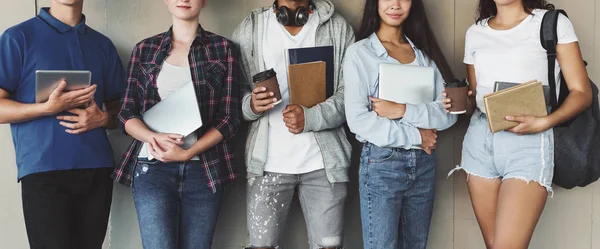 Adolescentes estudiantes sosteniendo libros y gadgets en las manos —  Fotos de Stock