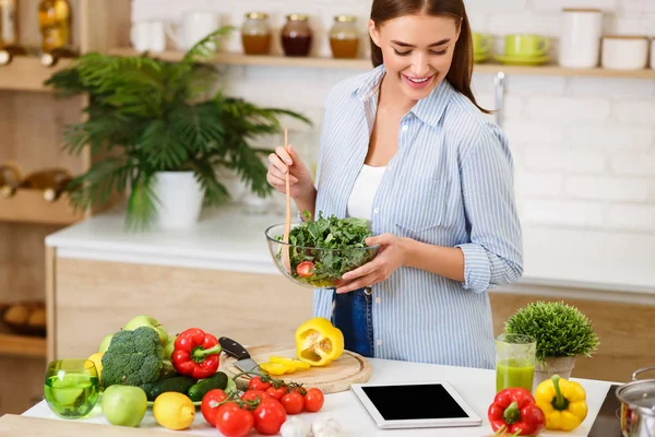 Kvinna matlagning sallad, Letar efter recept på nätet — Stockfoto