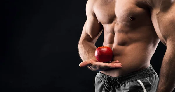 Hombre irreconocible sosteniendo manzana roja en su musculosa mano —  Fotos de Stock