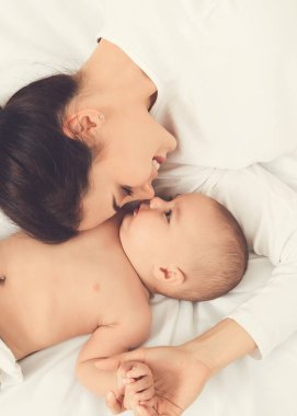 Anne ve küçük bebek burun yatakta yatan