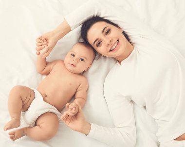 Mutlu anne ve bebek yatakta yatarken görünümü top