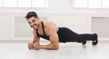 Yakışıklı sportif adam tahta yapıyor ve gülümsüyor