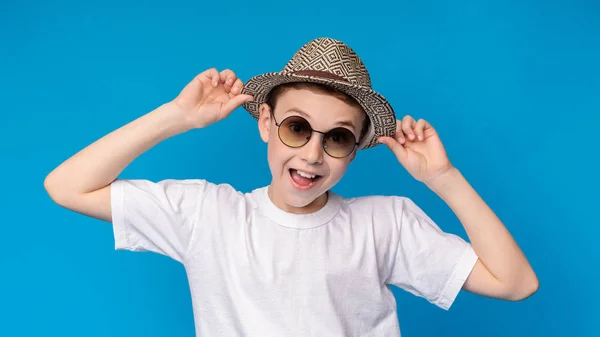 Retrato de niño alegre y elegante en gafas de sol y sombrero de mimbre — Foto de Stock