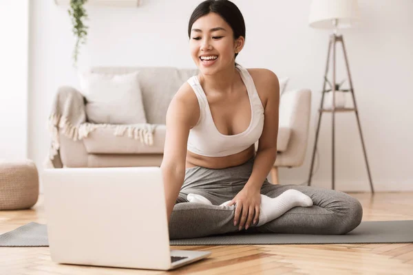 Mädchen macht Yoga-Übungen und schaut Unterricht auf Laptop — Stockfoto