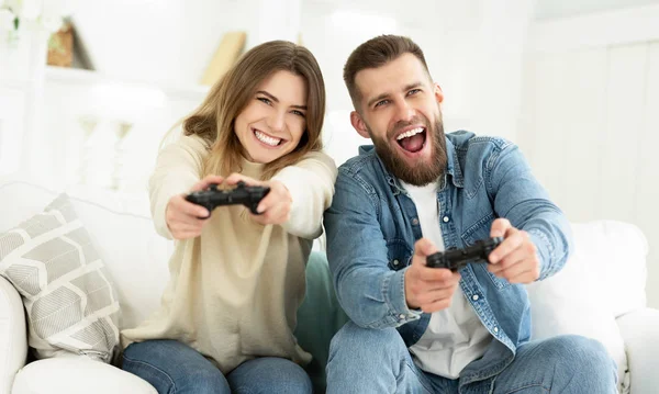 Lachendes Paar spielt Videospiele am Steuerknüppel — Stockfoto