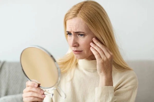 Cura della pelle antirughe. Donna triste guardando nello specchio — Foto Stock