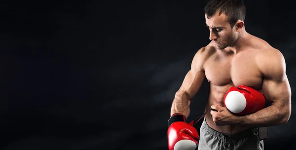 Boxer voorbereidingen voor vechten, het dragen van zijn rode handschoenen voor het boksen — Stockfoto