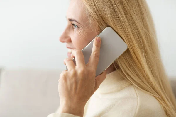 Reife blonde Frau telefoniert, Seitenansicht — Stockfoto