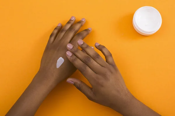 Mujer afroamericana aplicando crema cosmética en la piel —  Fotos de Stock