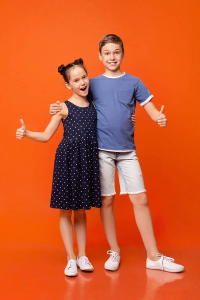 Bonito menino e menina mostrando polegar acima gestos — Fotografia de Stock