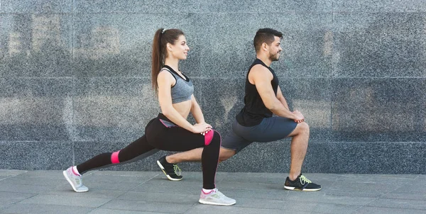 Pareja joven en forma haciendo ejercicios de estiramiento al aire libre en la ciudad — Foto de Stock