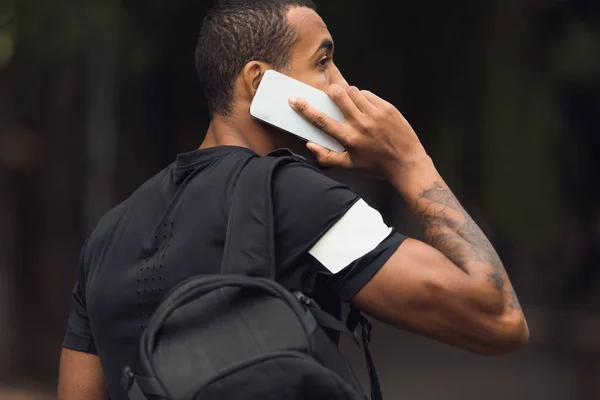 Sportieve man met rugzak praten op telefoon — Stockfoto