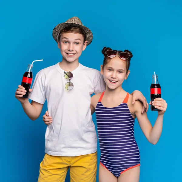 Fröhliche Geschwister in Sommerkleidung genießen erfrischendes Getränk — Stockfoto