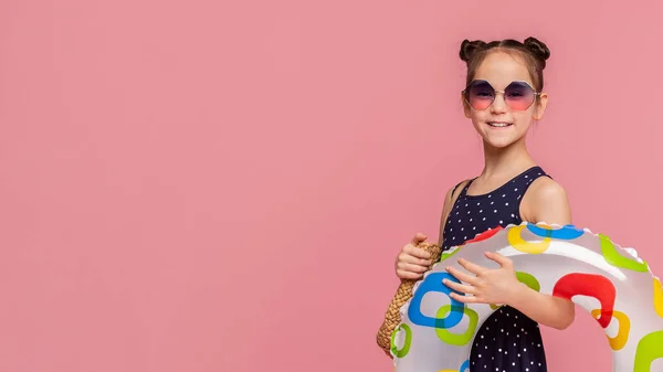 Menina adorável com anel inflável sorrindo no panorama rosa — Fotografia de Stock