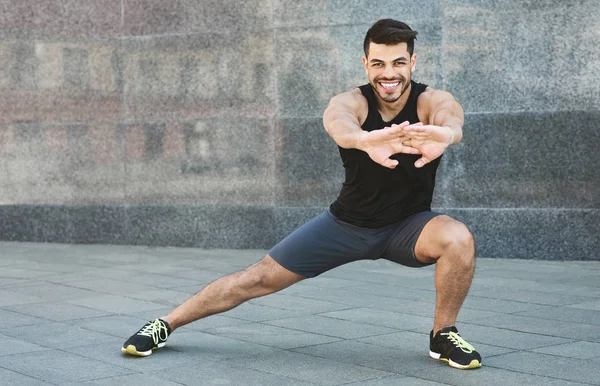 Młody muskularny Człowiek robi ćwiczenia rozciągające na zewnątrz — Zdjęcie stockowe