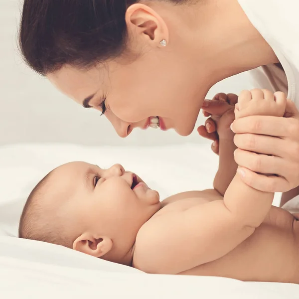 Mutter spielt mit ihrem Baby im Schlafzimmer. — Stockfoto