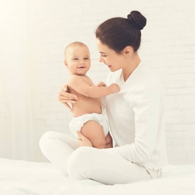 Genç Anne şirin yeni doğmuş çocuğunu sarılma