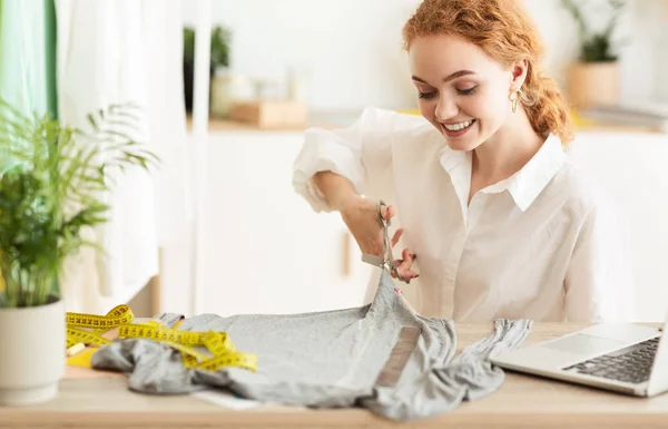 Modedesignerin schneidet grauen Stoff in Werkstatt — Stockfoto