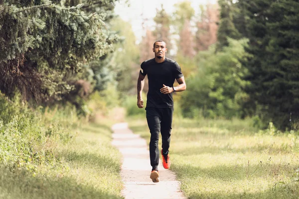 Спортивный человек бегает в парке во время утренней тренировки — стоковое фото