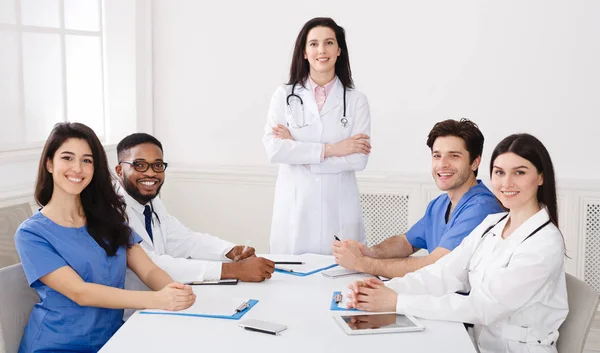 Médicos mirando la cámara, sentados en la sala de oficina del hospital — Foto de Stock